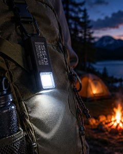Vellcom™ Mini Clip-On COB Rechargeable Light clipped to a backpack at a campsite