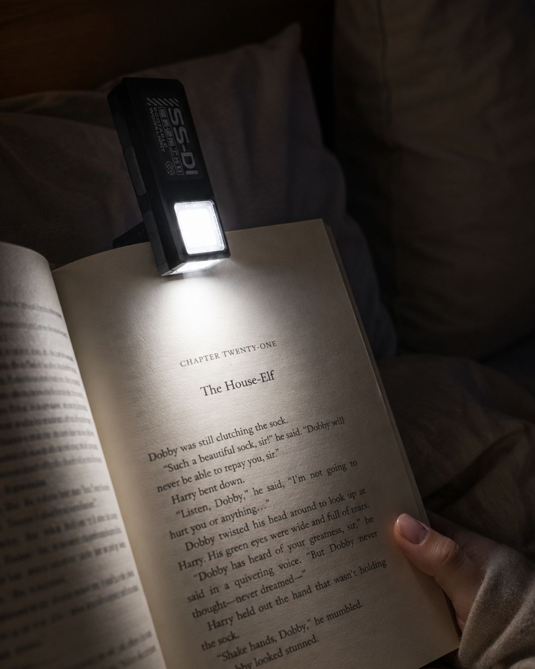 Vellcom™ Mini Clip-On COB Rechargeable Light clipped to a book and lighting the page